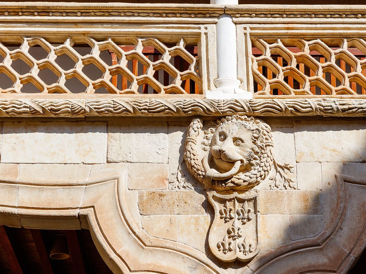 A carved lion's head holding the Maldonado coat of arms in the courtyard
